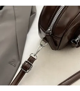Detailed close-up of premium silver-tone hardware and glossy dark brown leather finish
