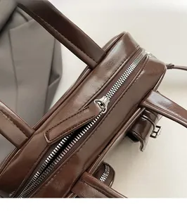 Detail of smooth silver zipper and dark brown leather texture on commute handbag