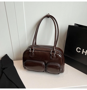 Dettaglio borsa a spalla in pelle marrone lucida con due tasche con cerniera
