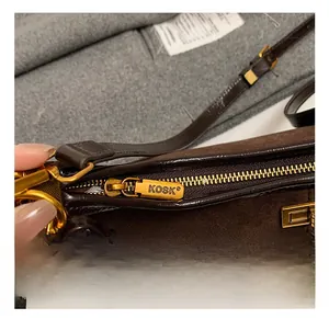 Nahaufnahme des goldenen Reißverschlusses und der Wildlederkonstruktion der Tasche