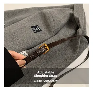 Detail eines verstellbaren dunkelbraunen Leder-Schultergurts mit goldener Schnalle