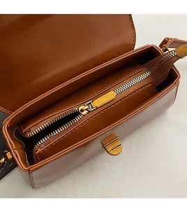 Detail of brown leather handbag interior with golden zipper and organized compartments