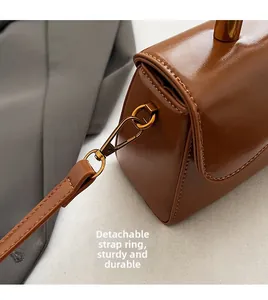 Detail of the durable detachable D-ring and metal buckle on the brown leather handbag