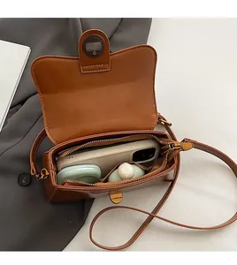 Interior view of brown leather crossbody bag showing spacious storage and phone compartment