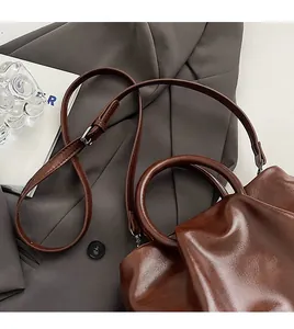 Détail du sac en cuir plissé marron brillant avec poignée et boucle métallique