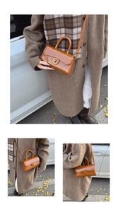 Close-up of vintage brown leather handbag featuring a golden circular twist-lock clasp