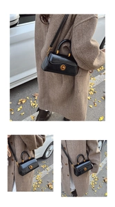Outdoor street view of a black glossy crossbody bag with golden round swivel lock