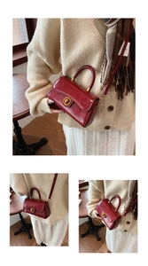 Macro shot of retro red leather handbag featuring antique bronze metal twist lock closure