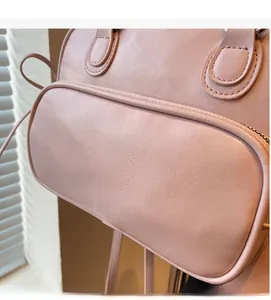 Close-up of soft pink PU leather bowling bag showing zipper pocket and fine stitching detail