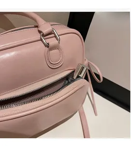 Detail view of pink PU leather handbag showing internal zipper pocket with a lipstick inside