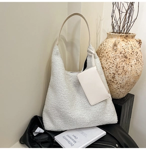 Détail du sac hobo en polaire crème avec poignée en cuir et pochette amovible assortie