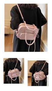 Detailed view of pale pink faux leather handbag with silver zippers and adjustable straps