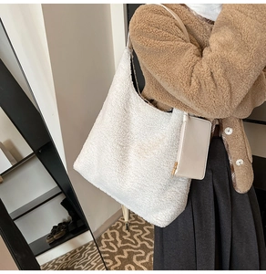 Detail view of white fuzzy sherpa tote bag with matching leather pouch on a model