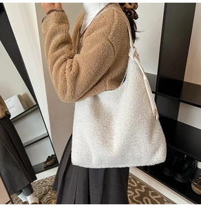 Detail view of large white faux shearling tote bag with leather strap and knot accent