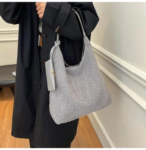 Detail shot of grey faux fur tote bag showing plush texture and small leather zip pouch