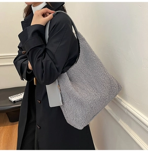 Close-up of grey sherpa tote bag with matching leather coin purse and soft fuzzy texture