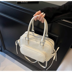Detailed macro view of white bowling bag with side ribbon ties and smooth PU texture
