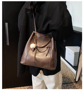 Dettaglio della borsa tote vintage in pelle marrone con ciondolo a gelato sulla modella