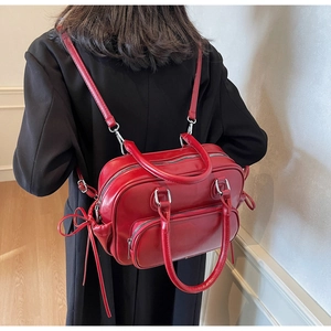 Detail of red bowling bag showing dual zipper compartments and bow accents on back