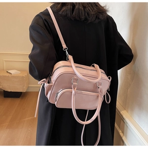 Pink multi-pocket PU leather crossbody bag worn by a model over a black jacket