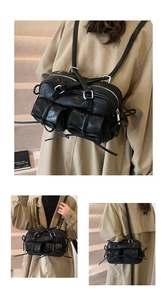 Detail view of a black Boston bag with silver zippers and multi-pocket leather texture
