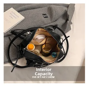 Detail view showing large interior capacity of a black Boston bag with daily essentials