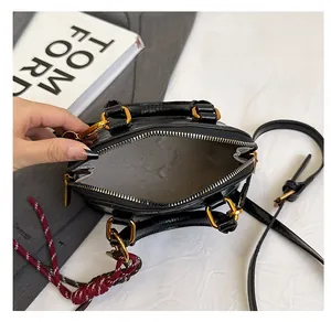 Top-down view of black crocodile pattern handbag showing spacious interior with metal zipper