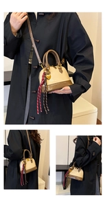 Detail view of retro beige and brown shell bag with heart lock and woven strap detail