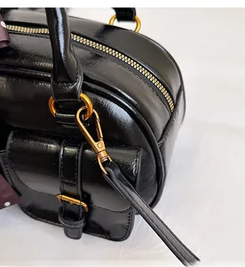 Detail of premium black leather bowling bag with shiny gold hardware and metal hooks