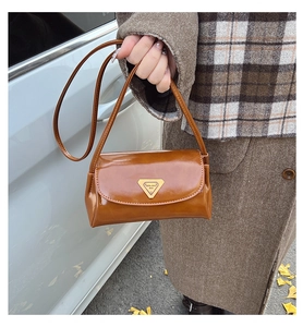 Detail of caramel brown oil wax leather shoulder bag with vintage triangle metal buckle