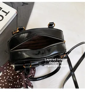 Detail view of black Boston bag interior with striped lining and divided pockets