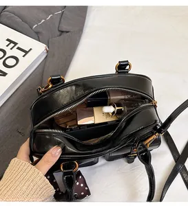 Macro shot of black leather bowling bag showing spacious interior with cosmetic items