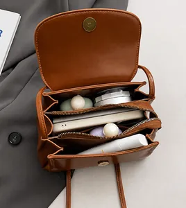 Detailed interior of vintage brown leather pillow bag showing multiple compartments