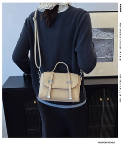 Close-up of beige corduroy crossbody bag featuring silver metal hardware and flap closure