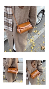 Detail of vintage oil wax leather crossbody pillow bag in brown with gold triangle logo