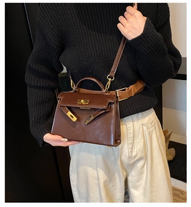 Vue détaillée du sac à main rétro en cuir marron avec une forme trapèze classique.