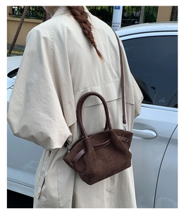 Detail of dark brown suede tote bag with textured finish and elegant leather straps