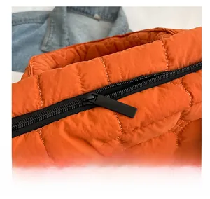 Macro detail of high-quality zipper on quilted orange tote bag with puffy diamond stitching