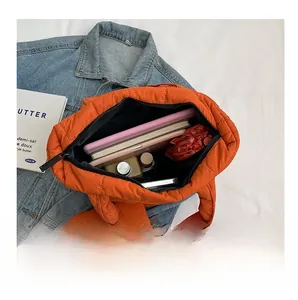 Interior view of orange quilted tote bag showing large capacity for laptop and cosmetics