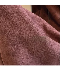 Gros plan détaillé du tissu en daim violet foncé montrant la texture mate et la finition