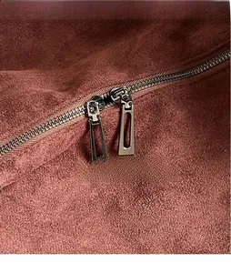 Gros plan sur les fermetures éclair en métal argenté d'un sac cabas en daim marron