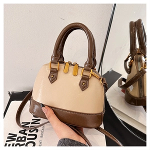 Detail of two-tone shell handbag with cream synthetic leather and brown metallic hardware