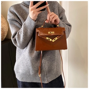 Vue détaillée du sac à main Kelly en cuir vernis marron rétro, élégant sac bandoulière.