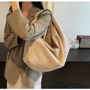 Gros plan détaillé d'un grand sac cabas en daim mat kaki porté à l'épaule pour le quotidien
