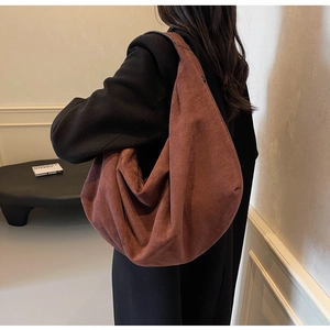 Gros plan sur un grand sac cabas en daim marron foncé avec texture plissée chic