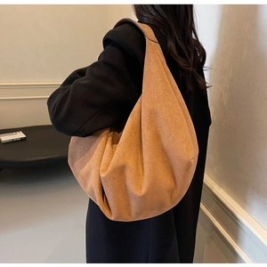 Close-up of caramel suede oversized tote bag with wide shoulder strap on model