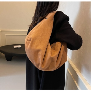 Caramel suede crescent tote bag with soft folds and large capacity worn on shoulder