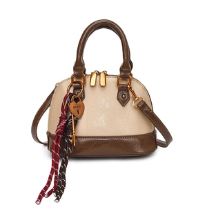 Chic two-tone shell handbag in beige and dark brown with heart charm and crossbody strap