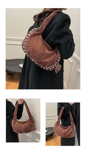 Détail d'un sac hobo en daim marron avec des clous argentés et un charmant cœur en relief