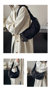 Détail du sac hobo en daim noir avec rivets métalliques argentés et pendentif en forme de cœur